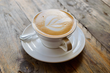 cappuccino cup on the brown wooden table