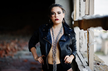 Brunette plus size sexy woman, wear at black leather jacket, lace panties and chain at abadoned...