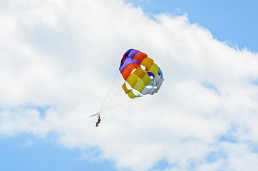 Colored parasail wing in the blue clouds sky, Parasailing also known as parascending or parakiting