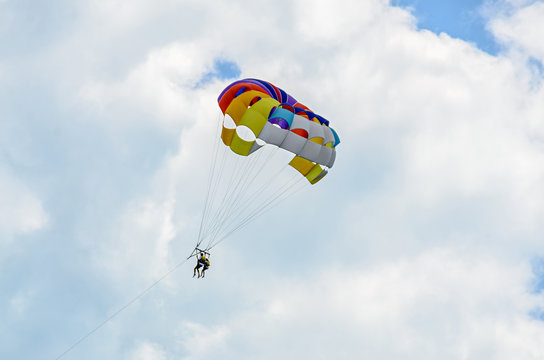 Colored parasail wing in the blue clouds sky, Parasailing also known as parascending or parakiting