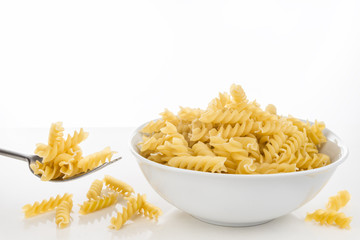 Nudeln, Pasta, Penne, Fusilli, roh, vor hellem Hintergrund auf weißem Tisch