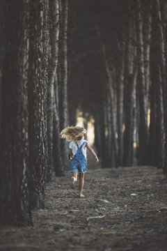 Happy Child Running In Forest