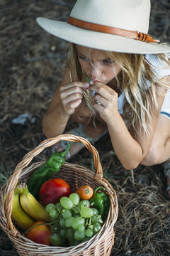 Child eating fruit from basket