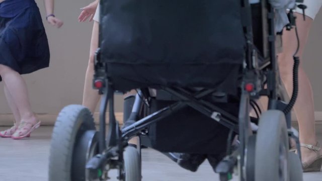 Legs of women dancing in choreography with handicapped persons in wheelchairs
