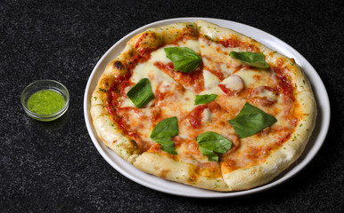 Pizza margarita on a white plate and blue background