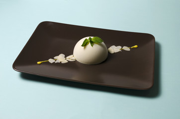 Panna cotta on a plate with almond petals