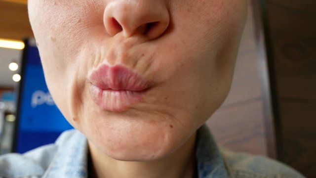 A close-up of the bottom of the female face. The girl makes a different grimace with her mouth.