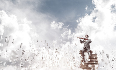 Obraz na płótnie Canvas Handsome violinist play his melody and symbols fly around in air