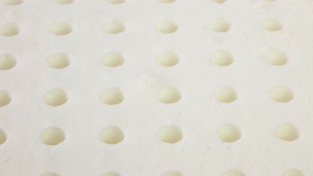 Mani di un uomo che stanno toccando un materasso in memory foam per testare la sua efficacia.
