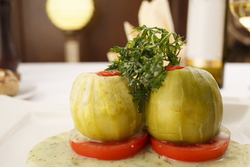 Stuffed zuchini arranged on a plate, Wineglass in the background, Traditional dish in elegant setting, Selective focus with soft light