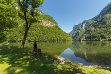 Ragazza in riva al lago di montagna