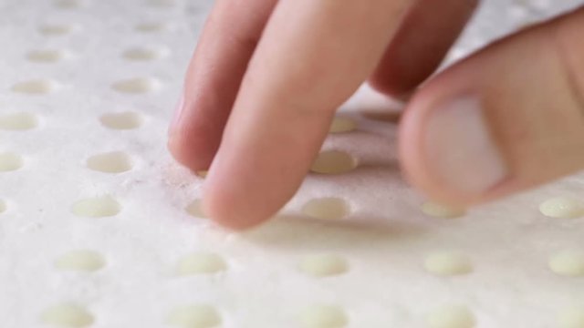Mani di un uomo che stanno toccando un materasso in memory foam per testare la sua efficacia.