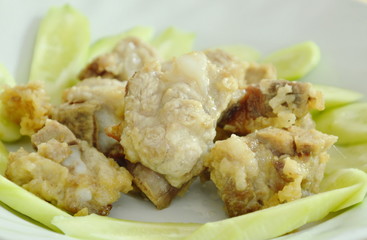 fried pork rib with flour and slice cucumber on plate