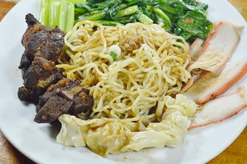 Chinese egg noodles topping slice barbecue pork and braised rib with dumping dressing sweet black sauce on plate