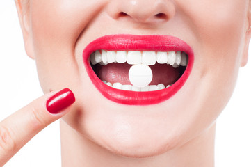 Female mouth with red lips and medicine pill