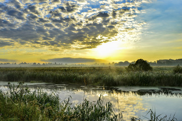 Photo with a sunny summer sunrise over the river
