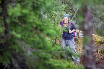 ,Young woman backpacker with backpack traveling alone forest