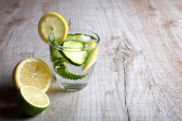 Water with lemon,lime  mint and cucumber on the wooden dark background. Water Detox.on wooden background