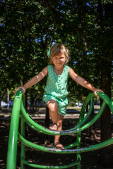 Fototapeta na wymiar Little girl on the playground in summer
