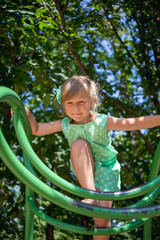 Little girl on the playground in summer