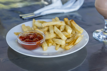 French fries with tomato sauce on white plate