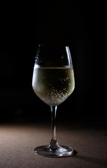 Glass of white wine on black background