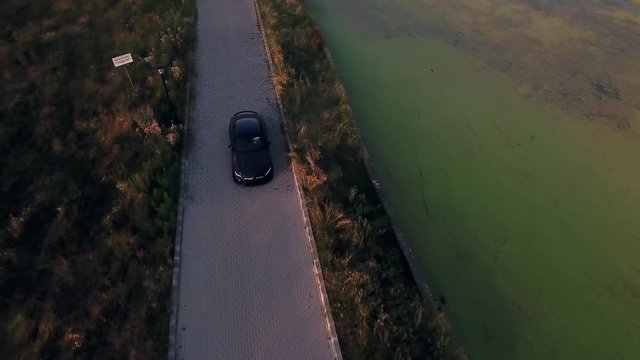 Aerial view of a car driving at sunset