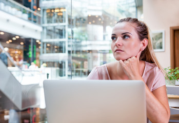 Business woman working with laptop at open space office in modern interior, freelance concept