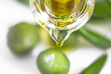 Oil flows out of the pot, olive twig, leave