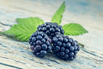 Close up of ripe blackberries over rustic turquoise wooden table