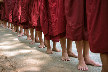 Buddhist monks queuing for food alms at monastery in Amarapura, Myanmar