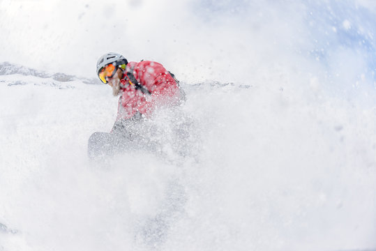 Skier in deep snow, splashing the camera