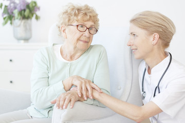 Friendly nurse visit old lady