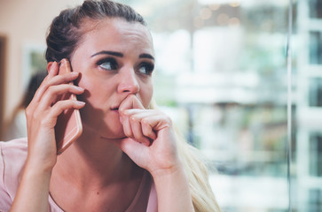 Stressed girl talking on phone at cafe