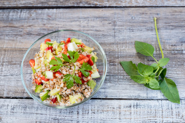 Bowl of fresh organic quinoa salad on wooden table. Shallow depth of field.
