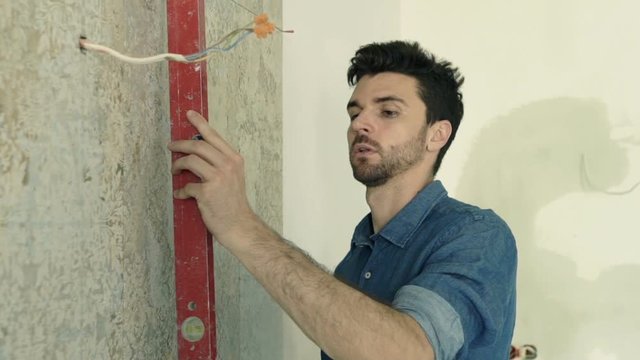Young man checking wall with level at new home, super slow motion 120fps 

