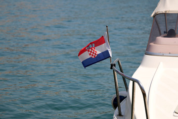Small Croatian flag on a boat, blowing in the wind. Selective focus. 
