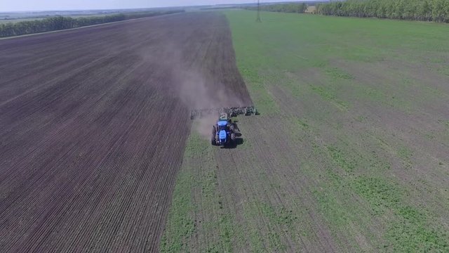 Tractor plowing the field . Chinese farmer on a small tractor plowing a field in spring day. Static, medium shot.