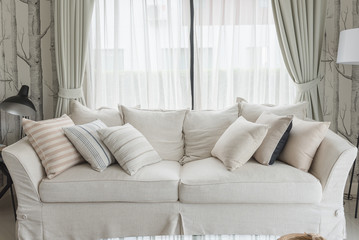 set of pillows on white classic sofa in living room