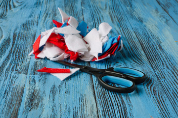 Scissors and scraps of cloth on blue wooden background. .Concept of creativity and sewing