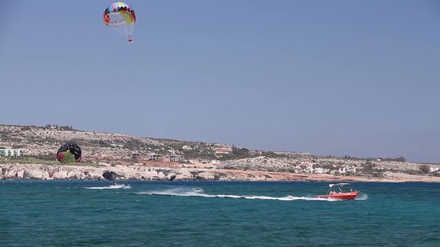 The boat rolls a man on a parachute, Sea entertainment, beautiful coast, good weather