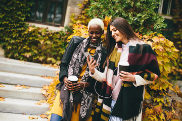 Pretty young multiethnic friends walking on autumn day