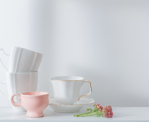 Clean dishes and flowers on wooden shelf