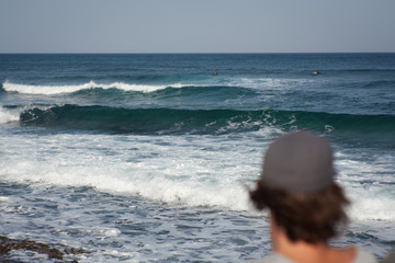 man sitting looiking at the sea