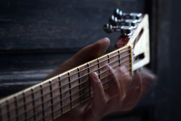 fingers on guitar dark background