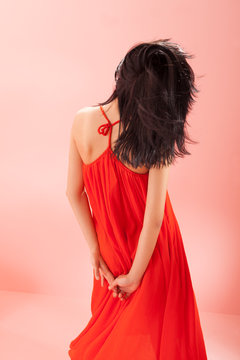 back of young brunette with a long red dress