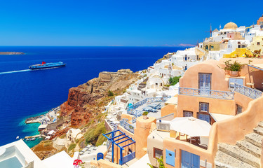 Obraz premium Breathtaking scenery of Oia village traditional Greek island architecture at Aegean sea and noon zenith sun flare background. Santorini island, Greece, Europe. Santorini is famous and popular resort.