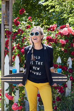 Portrait of senior woman with longboard