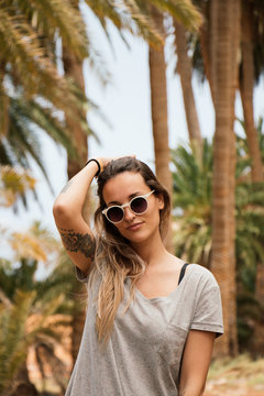 Portrait of pretty woman with palm tree in background