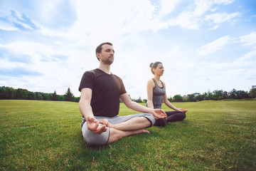 Naklejka na ściany i meble People practice acro yoga outdoors healthy lifestyle